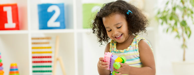 Smiling girl playing with toys